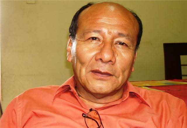 Mario Sabogal con camisa naranja, en interior