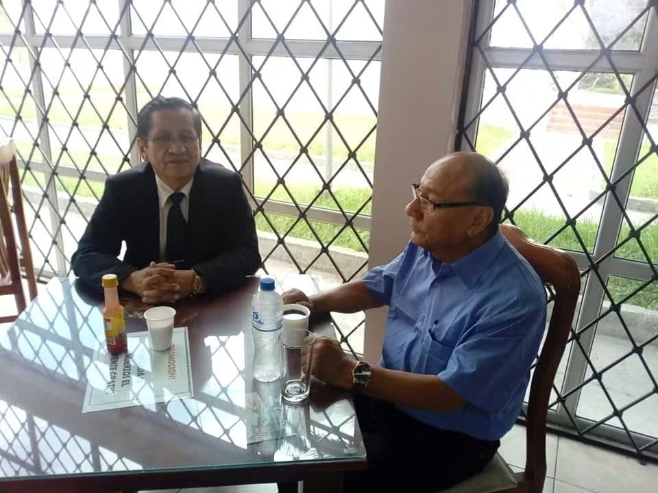 Mario Sabogal en una reunión académica, sentado a una mesa
