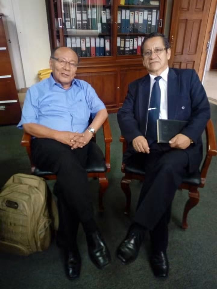 Mario Sabogal junto a un colega, en una biblioteca